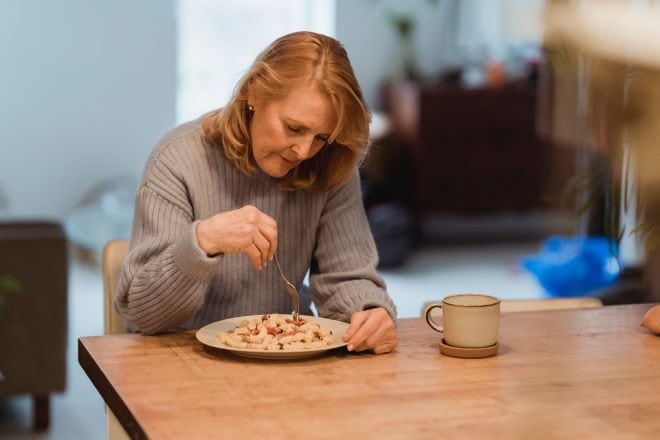 Alleenstaand en dementie Alleenstaande vrouw aan tafel aan het eten